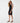 A woman wearing a black ruched midi dress