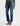 A woman wearing mid-rise medium blue wash straight leg denim with a distressed hem, fading, and gold stitching on a white background.
