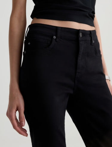 Person wearing black pants on a plain background