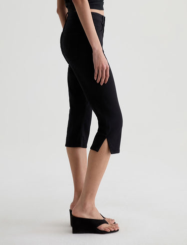 Person wearing black capri pants on a white background