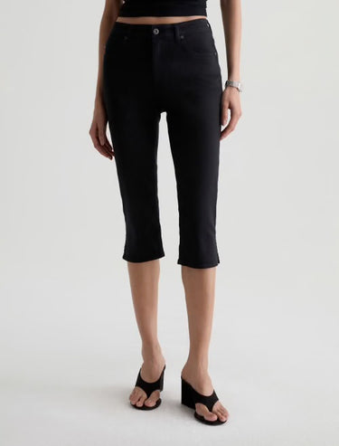 Person wearing black capri pants on a white background