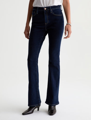 Person wearing dark blue jeans on a white background