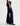 Dark blue flared jeans worn by a person on a white background