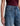 A woman wearing high rise barrel jeans in medium wash with a short sleeve maroon tee on a white background.