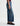 A woman facing sideways in high rise barrel jeans in medium wash with a short sleeve maroon tee and black loafers on a white background.