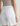 White shorts with a brand logo on a neutral background