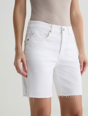 Person wearing white denim shorts on a plain background