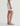 White pencil skirt worn by a person on a plain background