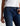 Person wearing blue jeans and a white top on a light background