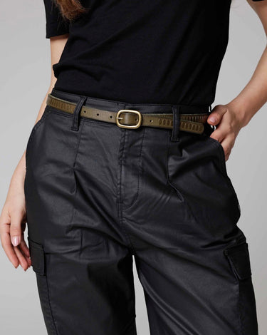 Person wearing black cargo pants with a belt on a gray background