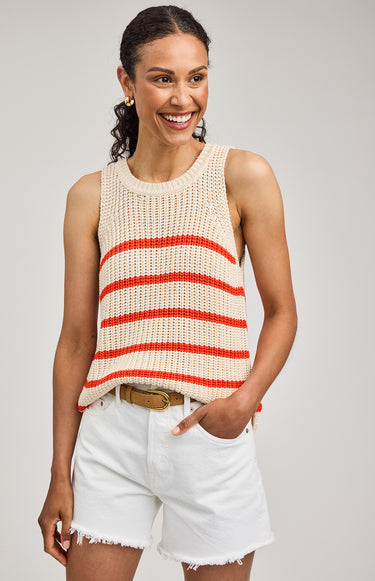 Woman wearing a sleeveless striped top and white shorts on a plain background