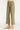 Green pants worn by a person on a white background