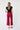 Person wearing wide leg cropped red pants and a black top on a white background