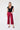 Woman wearing a black top and red cropped wide leg pants on a white background