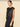 A woman wearing a sleeveless sequin top and black pants