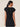 Woman wearing a black top and skirt against a beige background