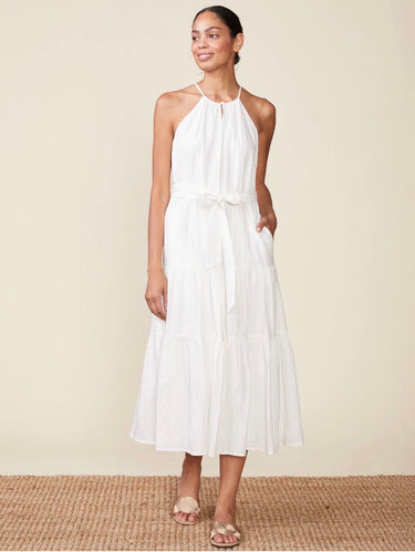 Woman wearing a white halter neck dress on a beige background