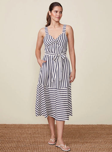 Woman wearing a black and white striped dress on a beige background