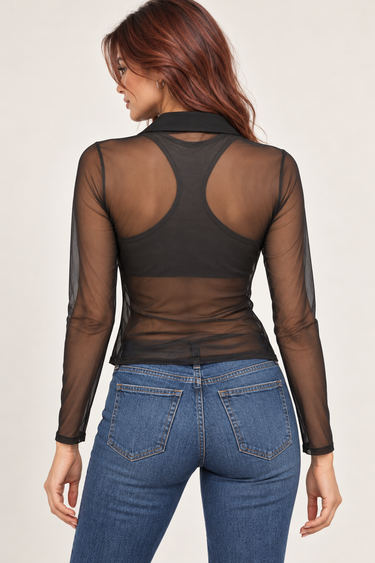 A woman shown from the back wearing a sheer black long-sleeve mesh top over a black sports bra, paired with blue jeans, against a light beige studio background.