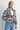 A woman wearing a blue plaid flannel jacket and blue jeans on a white background.