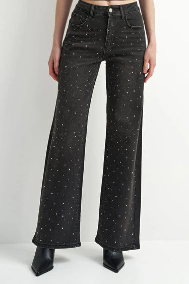 A model wearing black embellished wide leg jeans and black heeled boots on a white background.