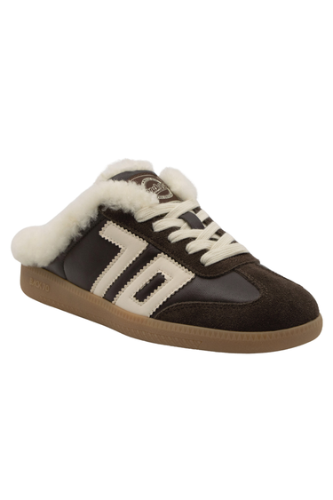 A low-top slip-on sneaker featuring dark brown leather and suede panels, a thick white faux-fur collar, white laces, and a gum brown sole, shown against a plain white background.