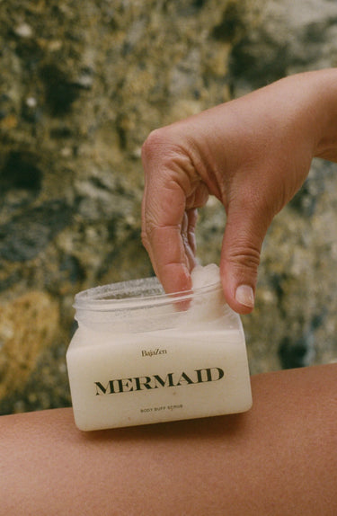 A woman using body scrub on the beach