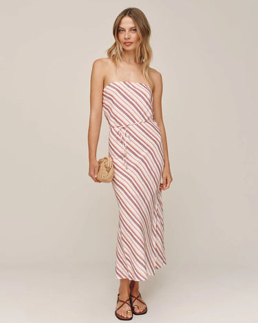 Woman wearing a strapless pink and white striped dress on a plain background