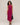 Woman wearing a sleeveless magenta dress with buttons on a plain background