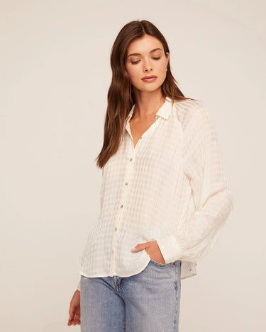 A woman wearing a relaxed blouse with a shadow satin gingham for a subtle sheen and elevated texture on a white background.