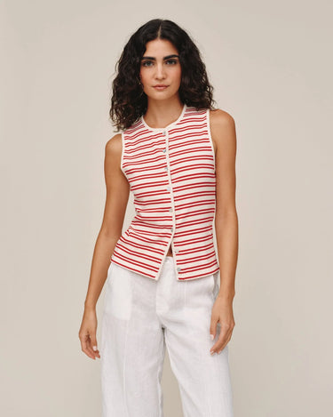 Woman wearing a red and white striped sleeveless top with a beige background