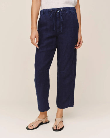 Navy blue pants worn by a person on a plain background