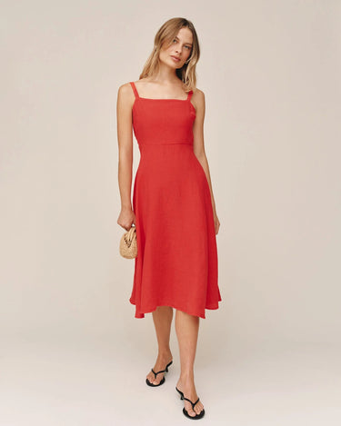 Woman wearing a red dress against a plain background