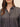 A close up of a woman wearing a stripe button down on a studio background.