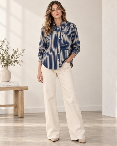 Front view of Bella Dahl Seamed Button Down Shirt in Vintage Navy Stripe styled with ivory wide-leg jeans