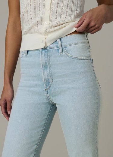 Light blue jeans worn by a person on a neutral background