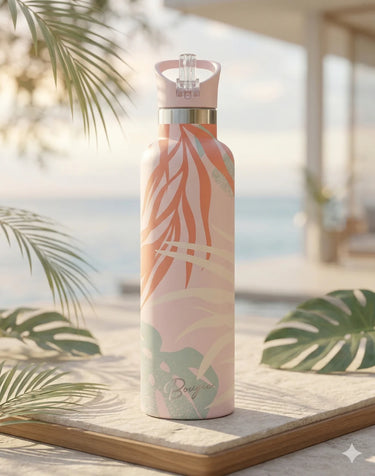 Tropical patterned water bottle on a wooden surface with blurred beach background