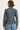 Person wearing a gray jacket and blue jeans on a white background