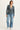 Woman wearing a blue jacket and jeans on a white background