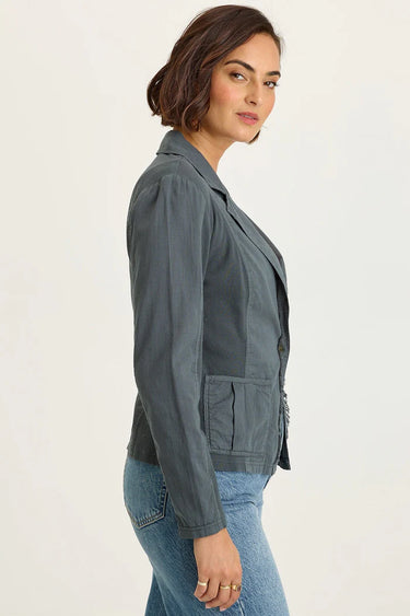 Woman wearing a gray jacket and blue jeans on a white background