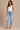 a woman wearing light wash cropped straight jeans on a neutral background