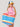 Woman holding a colorful striped tote bag against a plain background