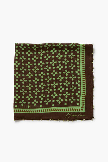 A square brown silk scarf with a green floral pattern and a decorative border, featuring a signature 'Char Lot' in gold on the bottom right corner, displayed flat against a white background.