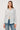 Woman wearing a striped shirt and jeans on a plain background