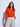 Woman wearing a bright orange crewneck sweater layered over a white mock-neck top with relaxed light beige wide-leg pants.