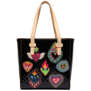 A black quilted patent leather tote bag with beige shoulder straps, decorated with multiple colorful heart-shaped patches on the front.