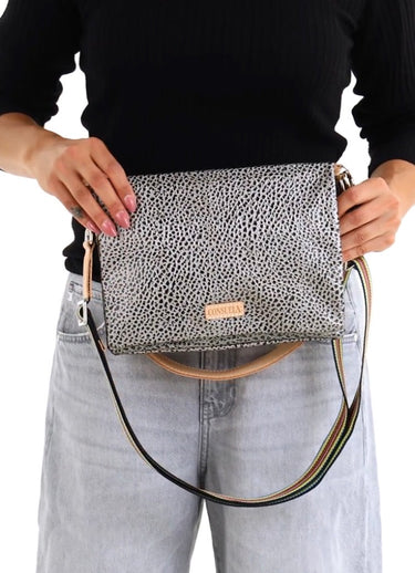 A shoulder bag with a gray and black leopard print pattern, featuring a light tan leather strap and a colorful rainbow-striped elastic band across the front.
