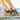 Navy wedge sandals with cork sole worn by a person on a stone surface