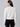 a woman wearing a white sequin cardigan and black leggings on a white background
