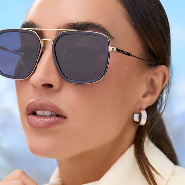 Close-up of a woman wearing sunglasses with a blurred background
